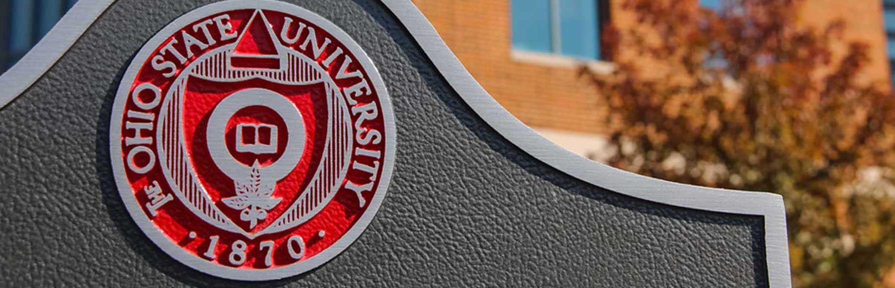 A picture of a sign on campus that has the Seal of Ohio State on it.