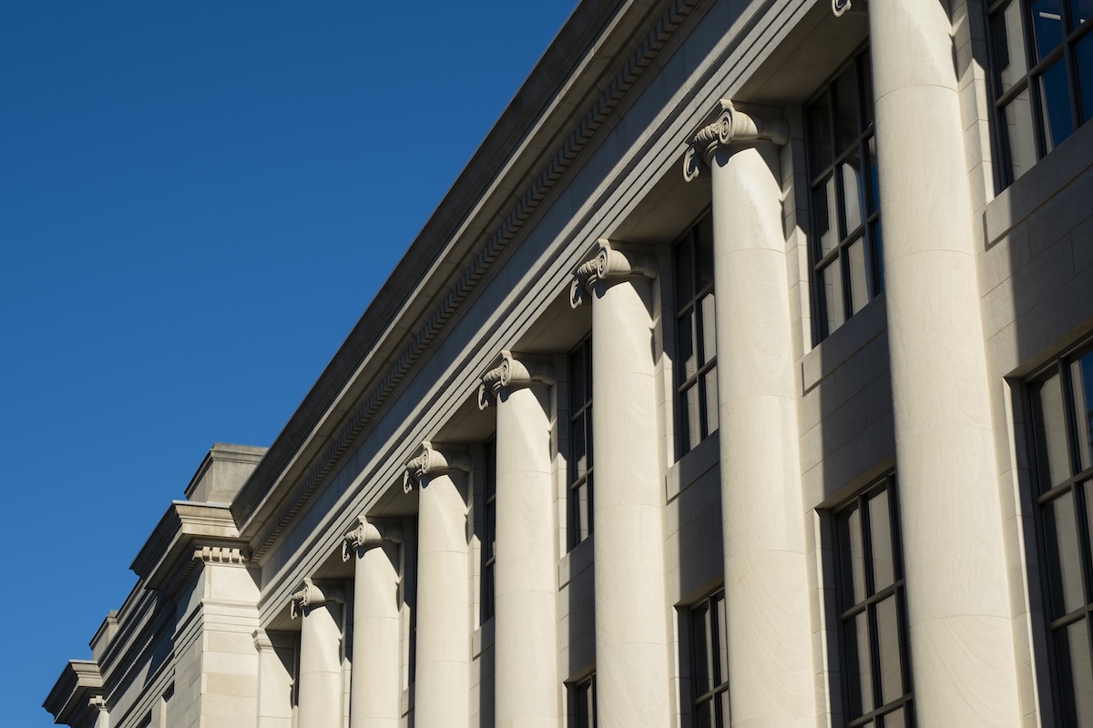 Picture of campus building with columns against a blue sky