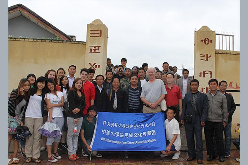 Group of students and faculty with a banner