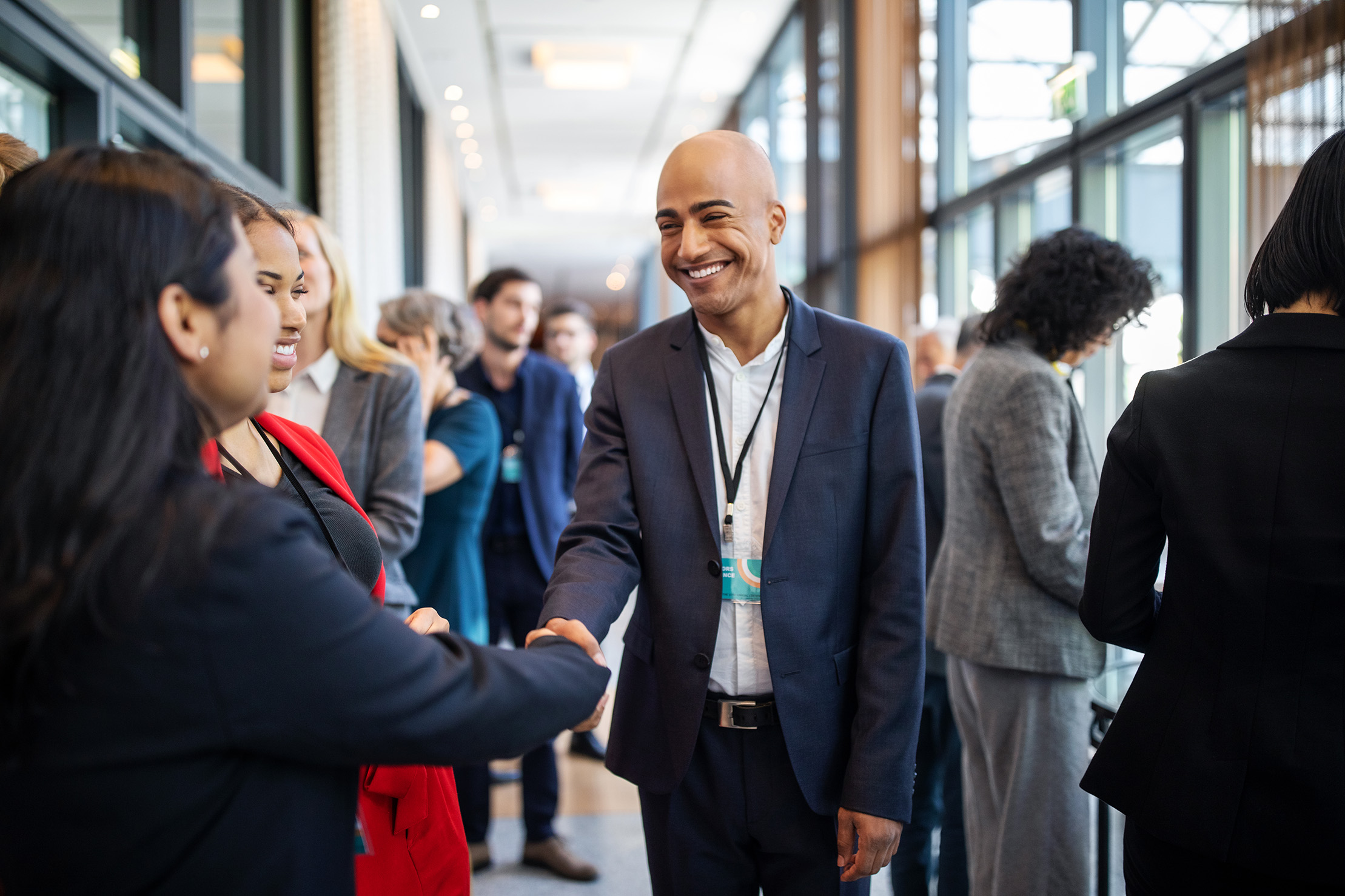 Two people shake hands during a professional social event