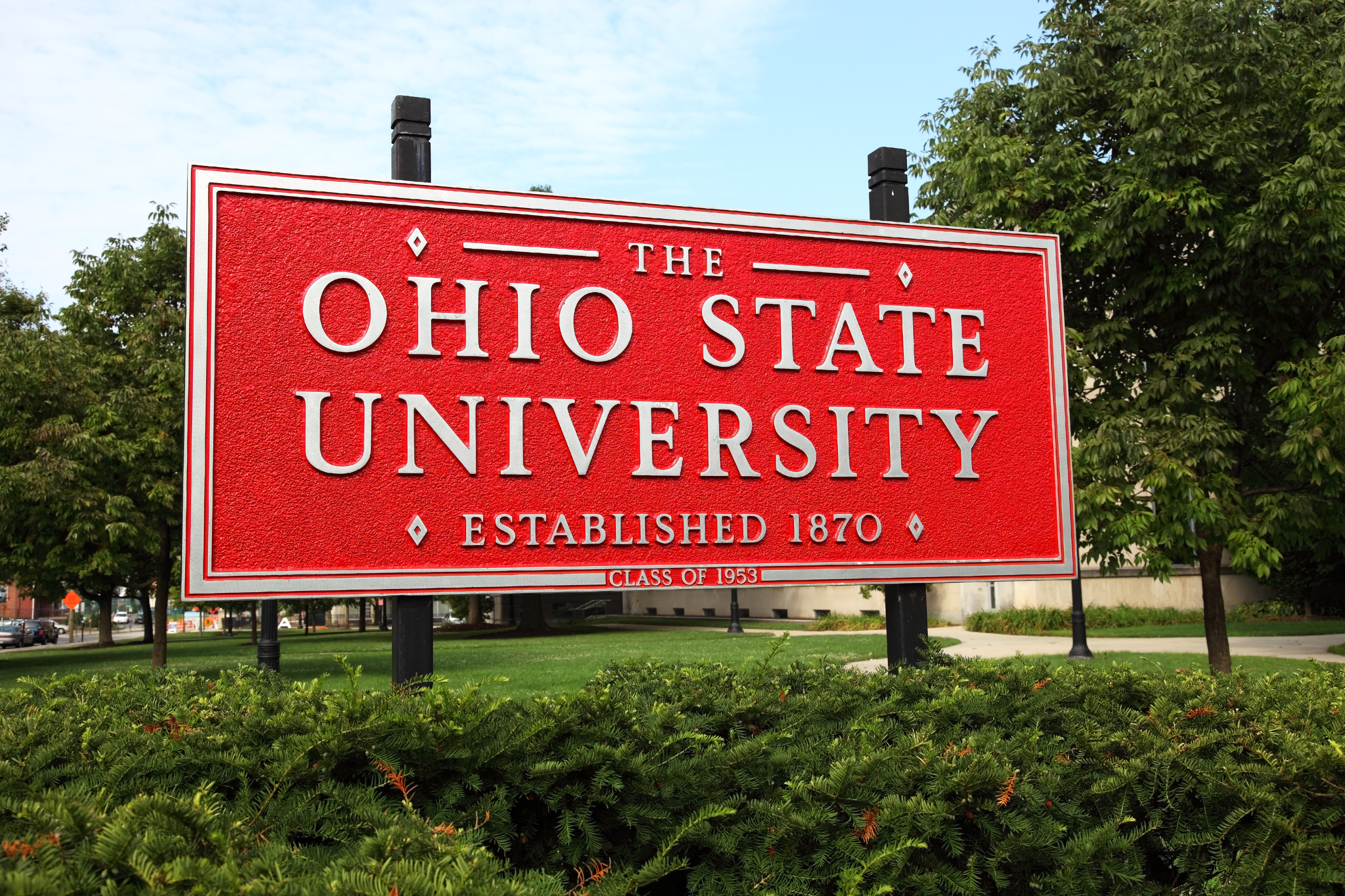 Large red sign set behind bushes that reads "The Ohio State University, Established 1870"
