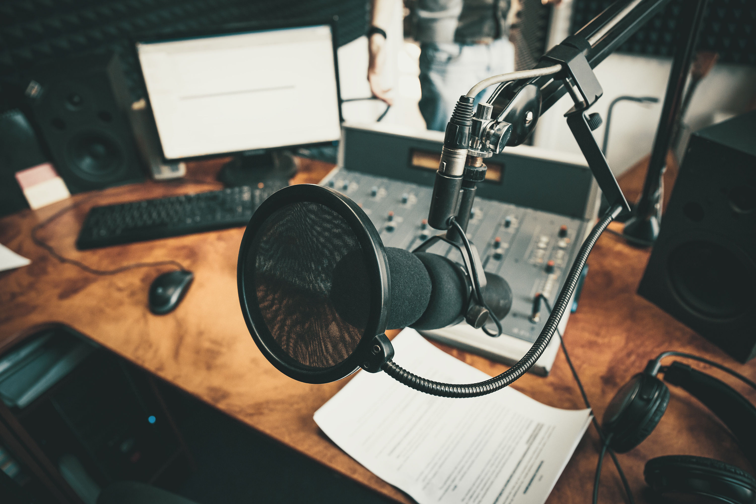 A podcast set-up with microphone, computer and audio mixer