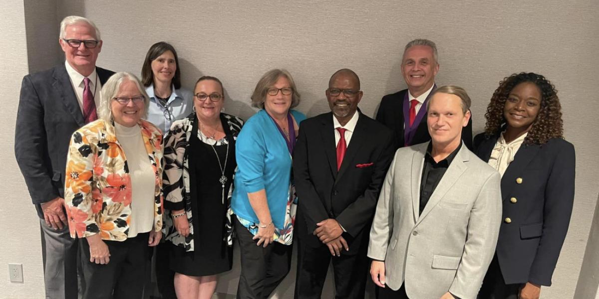 Nine members of the College of Education and Human Ecology gather at an annual conference.