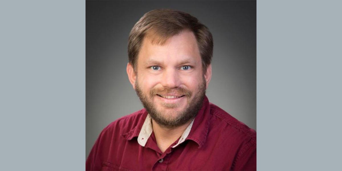 Headshot of Mark Mitton-Fry in business casual attire.