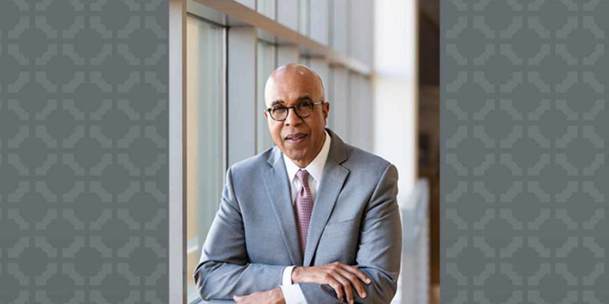 Don-Pope Davis poses in front of windows.