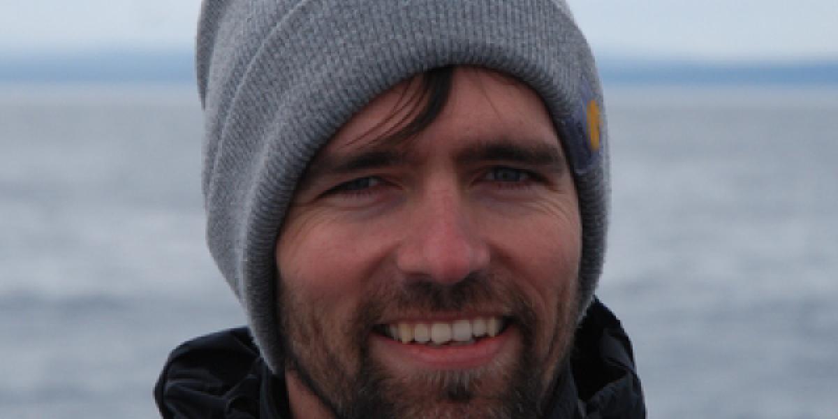 Picture of Bart Elmore in front of a large body of water.