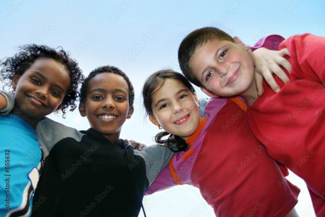 Four children with arms around soldiers are outside, looking down at the camera.