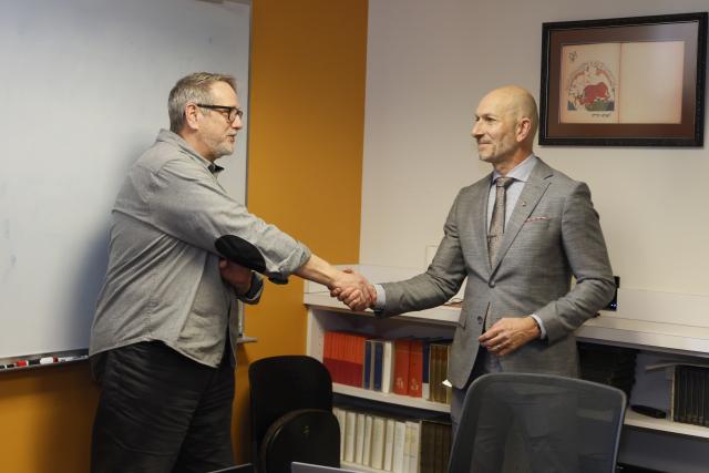 John Davidson shakes hands with Patrick Louchouarn.