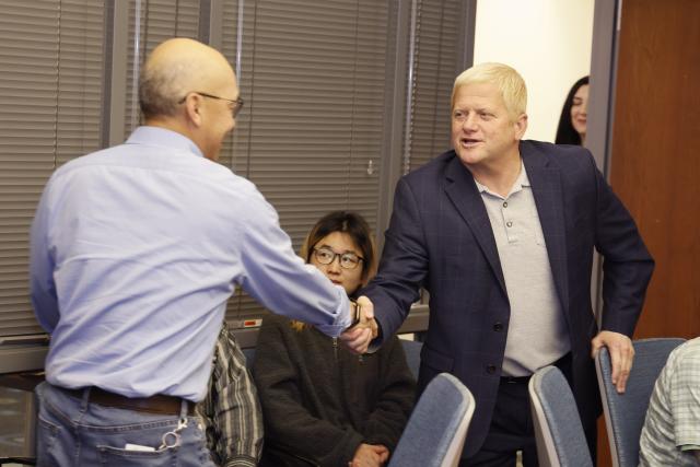 Shan-Lu Liu shakes hands with the dean