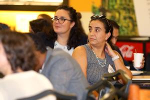 Two young faculty members seated and listening in the audience at the 2023 Promotion and Tenure Achievement Conference